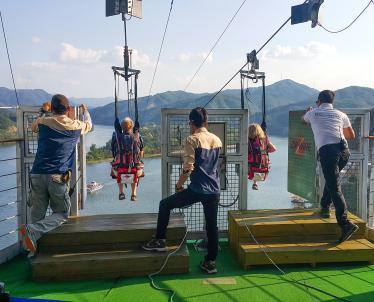 Two people strapped in and about to start the zip line at Nami Island 