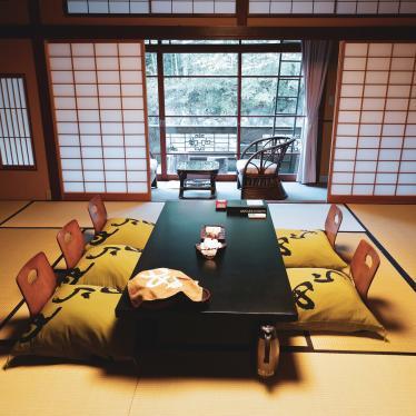 Tatami room with low-lying table and floor cushioned seats has beautiful view of the garden