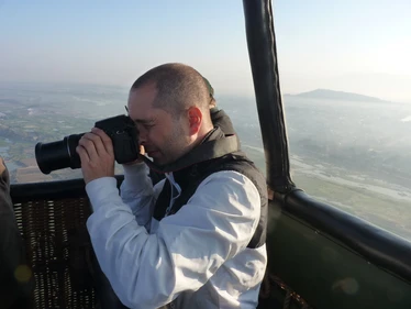 Man taking photograph in hot air balloon over Burma