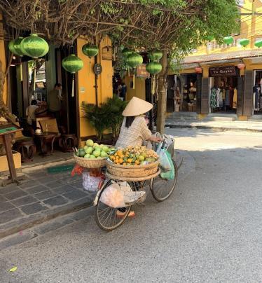 Hoi An, Vietnam - lady pushing bicycle