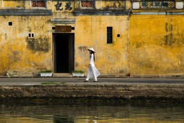 hoi an yellow wall woman walking vietnam