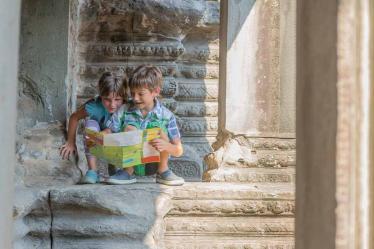 two young children looking at tourist map in Angkor wat, cambodi